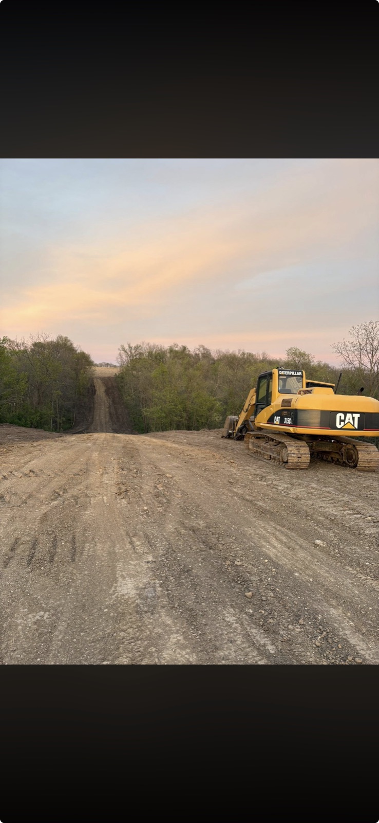 CAT excavator on a finished graded road at sunset